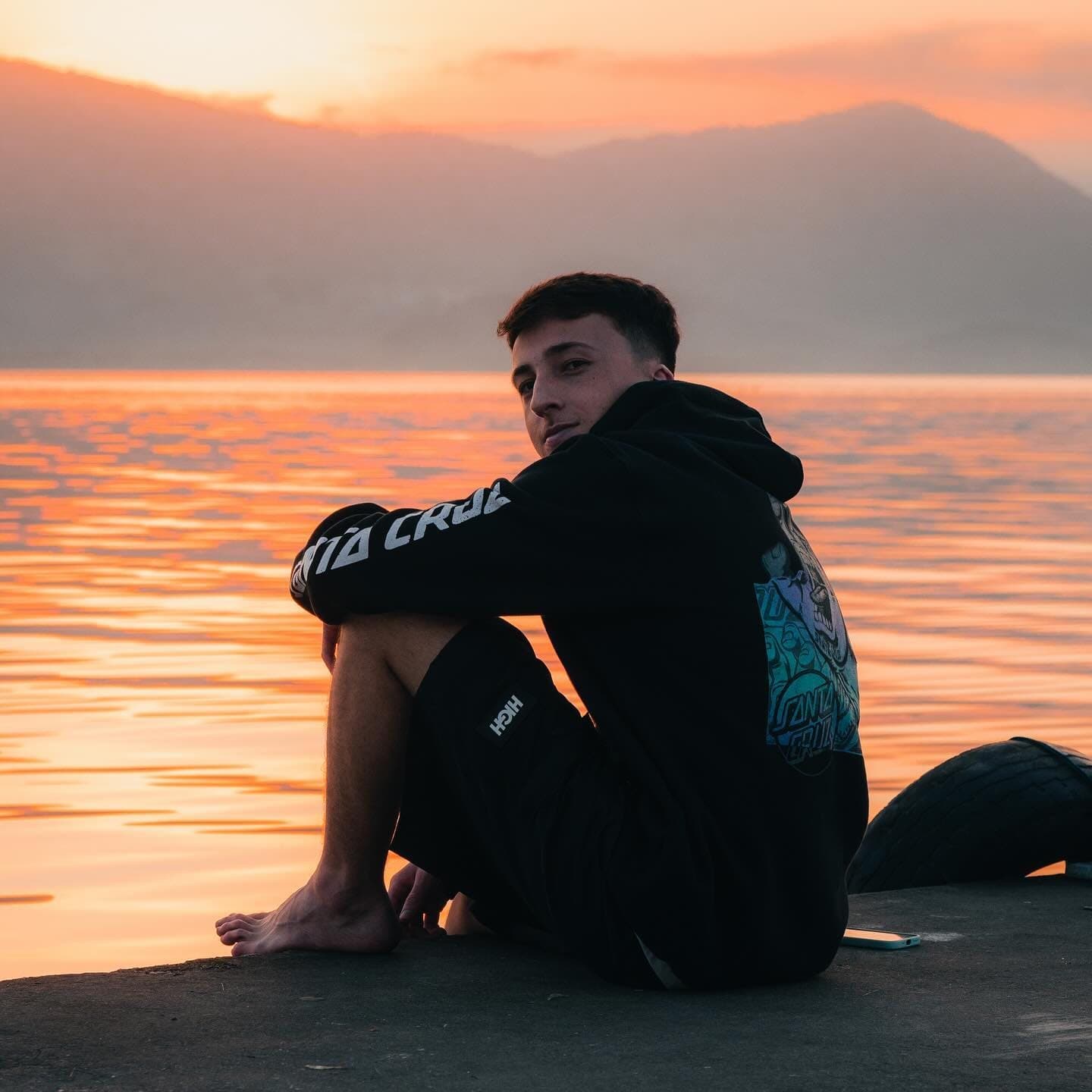 Stizi sentado nas pedras ao pôr do sol